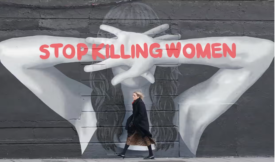 "stop killing women" written on the arms of a mural