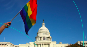 Image Caption: An image of the Capitol Building with an LGBTQ+ flag waving in front of it  Credit: TheSkimm