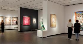 A photo taken inside the National Museum of Women in the Arts depicting guests looking at artworks.